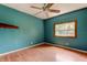 Inviting bedroom with light wood floors, teal walls, a ceiling fan, and a sunlit window at 4479 Newark N St, St Petersburg, FL 33714