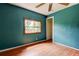 Bedroom with wood floors, teal walls, a ceiling fan, a window, and closet at 4479 Newark N St, St Petersburg, FL 33714