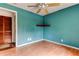 Bright bedroom with wood-look floors, teal walls, and a partially opened closet at 4479 Newark N St, St Petersburg, FL 33714