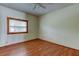 View of the bedroom with wood flooring, white walls, window, and ceiling fan at 4479 Newark N St, St Petersburg, FL 33714