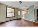 Shows the living room and connecting kitchen, with hardwood flooring, windows and white door at 4479 Newark N St, St Petersburg, FL 33714