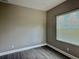 Bedroom with a window and sleek gray laminate flooring and light colored walls at 4510 Big Woods Way, Parrish, FL 34219