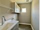 Bright laundry room with white countertops, upper cabinets, and wood-look flooring at 4510 Big Woods Way, Parrish, FL 34219