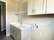 Spacious laundry room featuring a utility sink, white cabinets, and ample counter space at 4510 Big Woods Way, Parrish, FL 34219