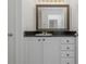 Bathroom vanity with granite countertop, framed mirror, and white cabinets at 501 Knights Run Ave # 1209, Tampa, FL 33602
