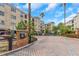 Brick-paved driveway leading to a gated entrance, enhanced by tropical plants and a charming fountain at 501 Knights Run Ave # 1209, Tampa, FL 33602