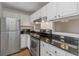 Modern kitchen features stainless steel appliances, granite countertops, and white cabinets at 501 Knights Run Ave # 1209, Tampa, FL 33602