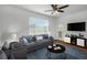 Living room featuring a ceiling fan, sofa, a side chair, a rug, a coffee table, and a TV at 501 Knights Run Ave # 1209, Tampa, FL 33602