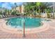 A serene community swimming pool surrounded by lush greenery and lounge chairs at 501 Knights Run Ave # 1209, Tampa, FL 33602