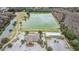 An aerial view shows community with a pond, parking, clubhouse, and wooded landscape at 5141 Riva Ridge Dr, Wesley Chapel, FL 33544