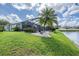 A beautiful view of the backyard, lake, and screen enclosed patio at 5141 Riva Ridge Dr, Wesley Chapel, FL 33544