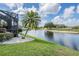 Large backyard with a lake view, green grass and a mature palm tree at 5141 Riva Ridge Dr, Wesley Chapel, FL 33544