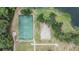 Aerial view of a basketball court and a sand volleyball court located next to a lake in the community at 5141 Riva Ridge Dr, Wesley Chapel, FL 33544
