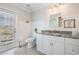 Bright bathroom features a white vanity with a gray granite countertop and tiled flooring at 5141 Riva Ridge Dr, Wesley Chapel, FL 33544
