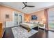 Cozy bedroom with peach walls, a ceiling fan, a bed with decorative pillows, and backyard views at 5141 Riva Ridge Dr, Wesley Chapel, FL 33544