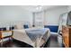 Cozy bedroom featuring a white frame bed, dark wood floor, and blue accent decor at 5141 Riva Ridge Dr, Wesley Chapel, FL 33544