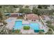 Aerial view of a community clubhouse, swimming pool, and playground with chairs and umbrellas at 5141 Riva Ridge Dr, Wesley Chapel, FL 33544