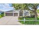 A charming home exterior with manicured landscaping, a mailbox and a three-car garage at 5141 Riva Ridge Dr, Wesley Chapel, FL 33544