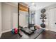 Home gym features equipment, weights, rubber flooring, and ceiling fan in a bright room at 5141 Riva Ridge Dr, Wesley Chapel, FL 33544