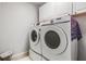 Laundry area with front load washer and dryer and white cabinets at 5141 Riva Ridge Dr, Wesley Chapel, FL 33544