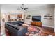 Open-concept living room with dark hardwood floors, a black sectional, and views of the kitchen at 5141 Riva Ridge Dr, Wesley Chapel, FL 33544
