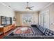 Spacious living room with hardwood floors, large windows, a ceiling fan, and a black sectional at 5141 Riva Ridge Dr, Wesley Chapel, FL 33544