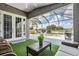 Screened patio with seating area and an outdoor view of the pool and lake at 5141 Riva Ridge Dr, Wesley Chapel, FL 33544