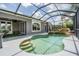Screened in pool with waterfall feature and lounge area and French doors to the home at 5141 Riva Ridge Dr, Wesley Chapel, FL 33544