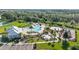 An aerial view showcasing a large community pool, splash pad, playground, and clubhouse set among trees at 5170 Sea Mist Ln, Wesley Chapel, FL 33545