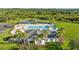 Aerial view of the community pool, clubhouse, pond, and surrounding green spaces showcasing the neighborhood's amenities at 5170 Sea Mist Ln, Wesley Chapel, FL 33545