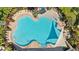 Aerial view of a uniquely shaped pool with shade sails at 5170 Sea Mist Ln, Wesley Chapel, FL 33545