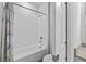 Full white tiled bathroom with a tub and shower head at 5170 Sea Mist Ln, Wesley Chapel, FL 33545