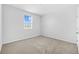 Bright bedroom with a window overlooking outside views and neutral carpeted floor at 5170 Sea Mist Ln, Wesley Chapel, FL 33545