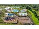 Community amenities include a clubhouse overlooking swimming pools, a splash pad, and a colorful playground near a pond at 5170 Sea Mist Ln, Wesley Chapel, FL 33545