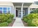 Home entrance with covered porch and manicured landscaping at 5170 Sea Mist Ln, Wesley Chapel, FL 33545