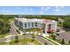 A modern apartment building featuring sleek architecture, red awnings, and ample parking in a landscaped setting at 5170 Sea Mist Ln, Wesley Chapel, FL 33545