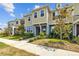 Inviting townhome exterior featuring lush landscaping, sidewalk, and neutral color palette on a sunny day at 5170 Sea Mist Ln, Wesley Chapel, FL 33545