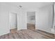 Neutral color hallway with wood floors leads to a half bathroom and other living spaces at 5170 Sea Mist Ln, Wesley Chapel, FL 33545
