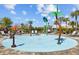 Entertaining splash pad with palm tree sprayers, lounge chairs, and shaded seating for Gathering fun at 5170 Sea Mist Ln, Wesley Chapel, FL 33545