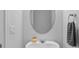 Close-up on half bathroom vanity, featuring a round mirror, sink, and towel ring at 5170 Sea Mist Ln, Wesley Chapel, FL 33545