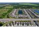 Scenic aerial view of a well-planned community with houses surrounding a long pond and green landscape at 5470 Flint Hills Dr, Wimauma, FL 33598