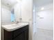 Bathroom vanity with speckled countertops and dark wood cabinets, leading to an open hallway at 5470 Flint Hills Dr, Wimauma, FL 33598