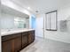 Bathroom featuring double vanity with tile floors, granite countertops and a large mirror at 5470 Flint Hills Dr, Wimauma, FL 33598