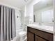 Bathroom featuring a shower with a gray curtain, vanity, and shelving unit at 5470 Flint Hills Dr, Wimauma, FL 33598