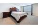 Bedroom with carpet, a large wooden bed and an end table at 5470 Flint Hills Dr, Wimauma, FL 33598