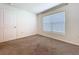 Neutral bedroom with a window that allows natural light in the carpeted room at 5470 Flint Hills Dr, Wimauma, FL 33598