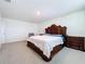 Spacious bedroom featuring carpet floors and a decorative wooden-framed bed with matching nightstands at 5470 Flint Hills Dr, Wimauma, FL 33598