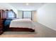 Spacious bedroom featuring carpet floors and a decorative wooden-framed bed and plentiful natural light at 5470 Flint Hills Dr, Wimauma, FL 33598