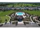 Aerial view of a community pool surrounded by lush landscaping, with plenty of space for relaxation and recreation at 5470 Flint Hills Dr, Wimauma, FL 33598