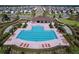 Stunning aerial view of the community pool with lounge chairs and lush landscaping in a desirable neighborhood at 5470 Flint Hills Dr, Wimauma, FL 33598